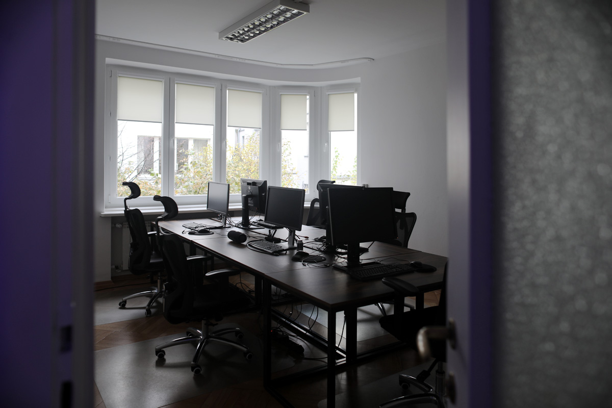 Open space z biurkami i dużymi oknami